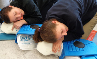 Students doinb breathing check during CPR