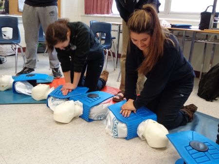 Students doing adult CPR on prestan mannikens
